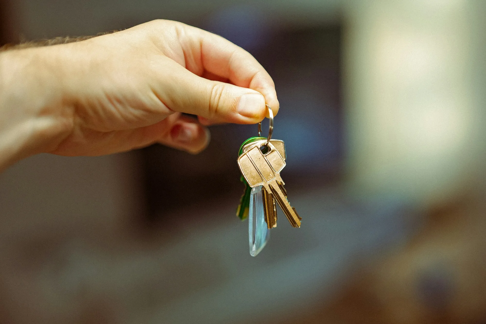 Hand holding a bunch of keys in a bright room